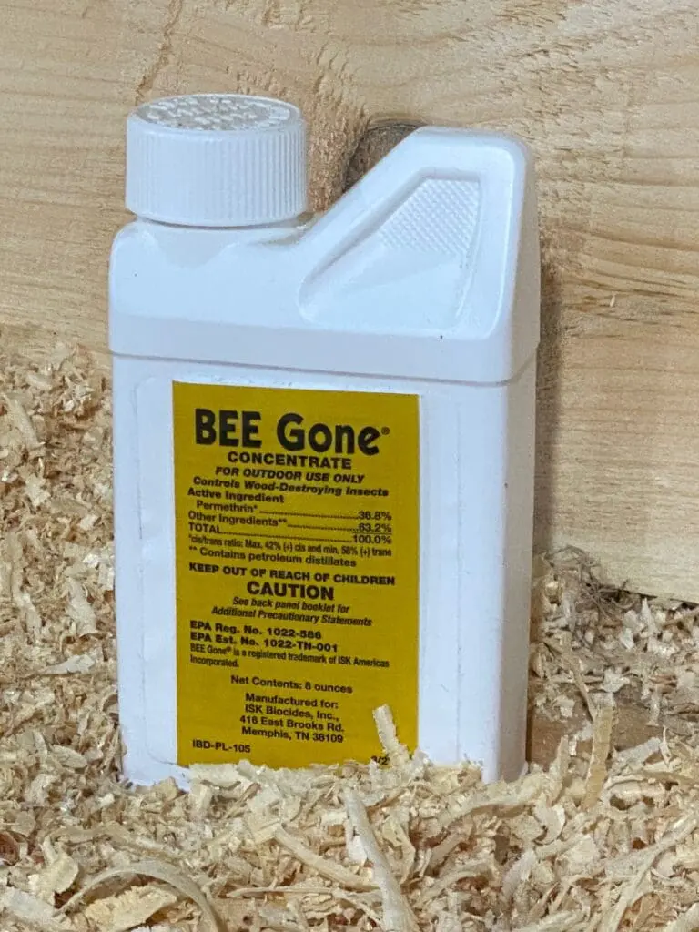 Bee Gone concentrate bottle on wood shavings.